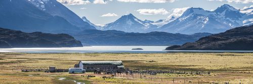 Argentina Travel Landscape Photography Estancia La Oriental farm buildings with Belgrano Lake and Andes Mountain Range behind Perito Moreno National Park Santa Cruz Province Patagonia Argentina South America