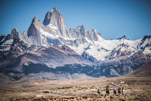 Argentina Travel Landscape Photography Gauchos riding horses and herding sheep with Mount Fitz Roy behind El Chalten Patagonia Argentina South America