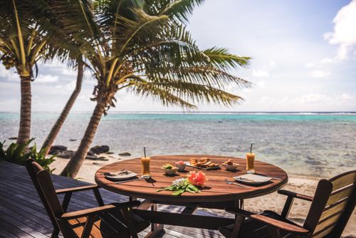 Cook Islands Landscape Travel Photography Luxury Villa accommodation with sea views of the tropical Pacific ocean and palm trees with breakfast table set up at the hotel Muri Rarotonga Cook Islands
