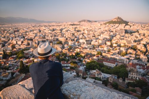 Greece Travel Photography Tourist man looking at view over Athens from Likavitos Hill on summer holiday at The Acropolis Attica Region Greece Europe
