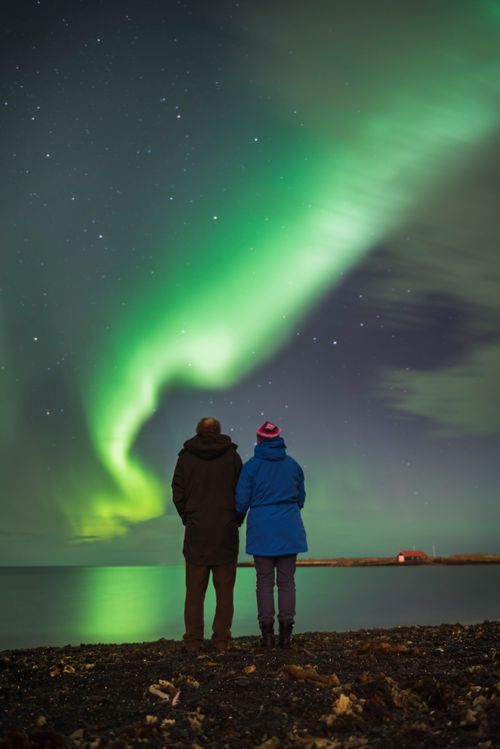 Iceland Travel Photography Couple watching the Northern Lights Aurora Borealis Reykjavik Iceland