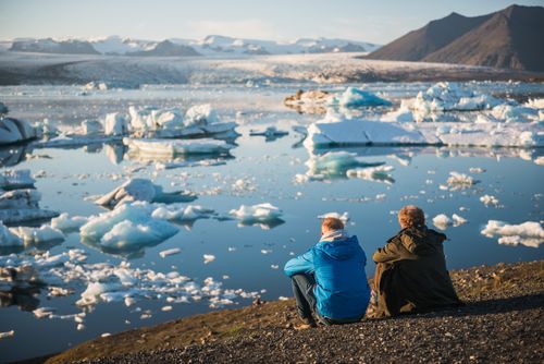 Iceland Travel Photography Father and son on holiday at Jokulsarlon Glacier Lagoon at sunset South East Iceland