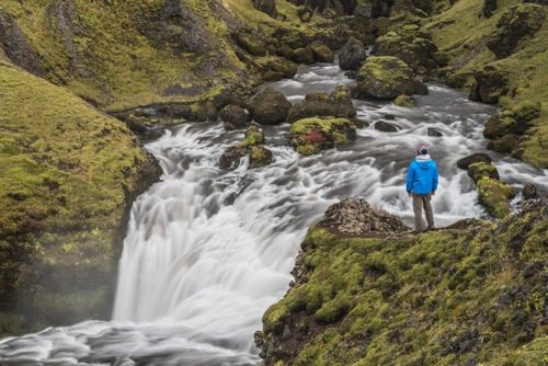 Iceland Travel Photography Tourist at a waterfall on the hiking trail above Skogafoss Waterfall Skogar South Region Sudurland Iceland