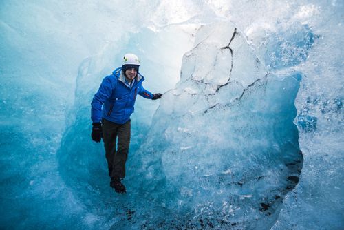 Iceland Travel Photography Tourist exploring an ice cave on Breidamerkurjokull Glacier Vatnajokull Ice Cap Iceland