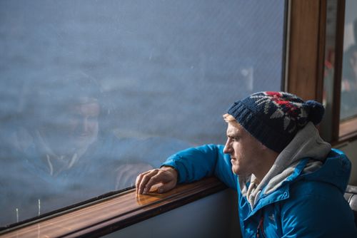 Iceland Travel Photography Tourist looking out of a window on a boat in Reykjavik Harbour Iceland Europe background with copy space