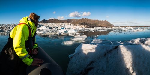 Iceland Travel Photography Tourist on a Zodiac boat tour of Jokulsarlon Glacier Lagoon a glacial lake filled with icebergs in South East Iceland