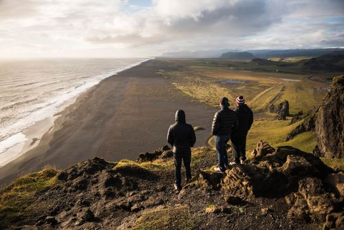 Iceland Travel Photography Tourists looking at the view at sunset from Dyrholaey Peninsula near Vik South Iceland Sudurland