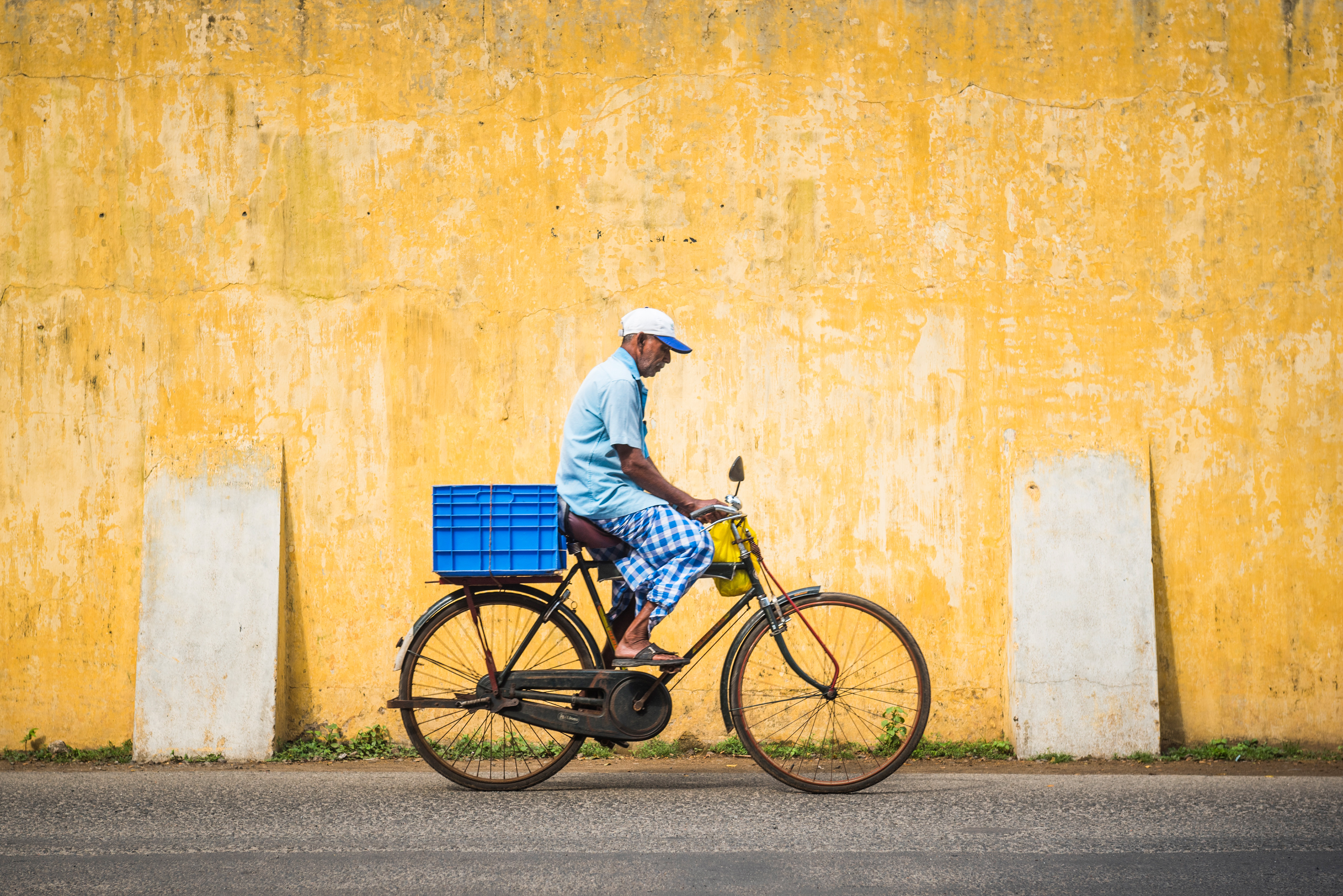 India Travel Street Photography Street scene of man on bicycle with yellow wall local life at Fort Kochi Cochin Kerala India