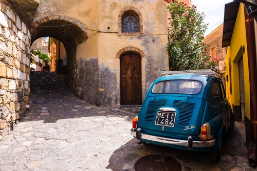 Italy Sicily Travel Photography Fiat 600 on the cobbled side street of Castelmola a typical Sicilian village near Taormina Sicily Italy Europe