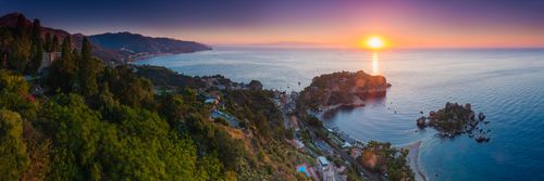 Italy Sicily Travel Photography Panoramic photo of the Sicilian Coast at sunrise showing Isola Bella Beach Taormina Sicily Italy Europe