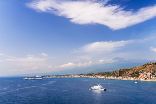 Italy Sicily Travel Photography Taormina luxury yacht and cruise ship in front of Mount Etna Volcano at Giardini Naxos Bay Sicily Italy Europe