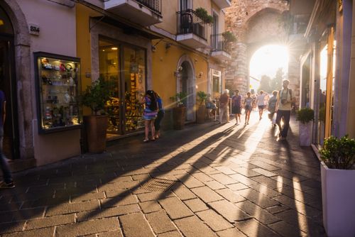 Italy Sicily Travel Photography Taormina tourists entering Corso Umberto the main street in Taormina at sunset Sicily Italy Europe