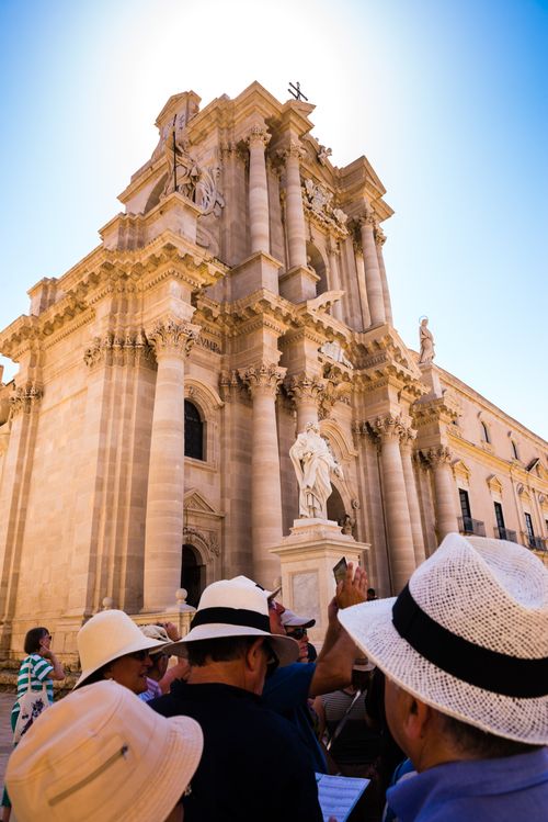 Italy Sicily Travel Photography Tourists on a Syracuse City Tour outside The Temple of Athena aka Syracuse Cathedral Ortigia Syracuse UNESCO World Heritage Site Sicily Italy Europe