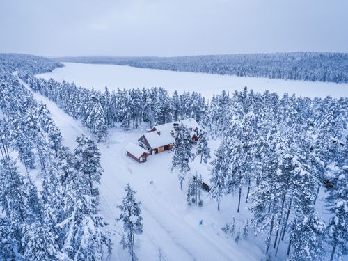 Lapland Finland Travel Photography Aerial drone photos of cabins huts and accommodation in the forest with snow covered winter landscape and trees in woods Torassieppi Arctic circle in Finnish Lapland Finland