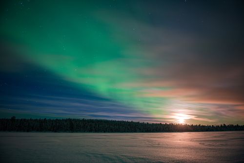 Northern Lights Landscape Photography Northern Lights aurora borealis and moon seen over a snow covered lake in winter in Finnish Lapland inside Arctic Circle in Finland