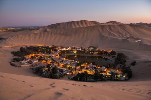 Peru Travel Photography Huacachina surrounded by sand dunes at night Ica Region Peru South America