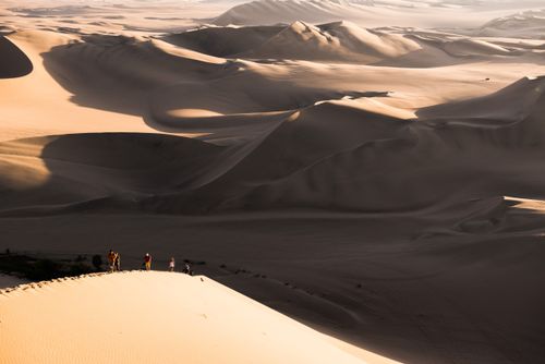 Peru Travel Photography People climbing sand dunes to watch the sunset over the desert at Huacachina Ica Region Peru South America