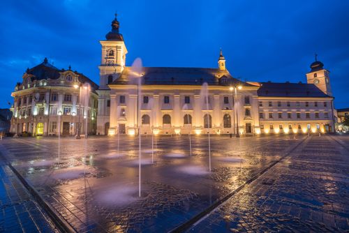 Romania Architecture Travel Photography Piata Mare Great Square at night with Sibiu City Hall on left and Sibiu Baroque Jesuit Church on right Transylvania Romania