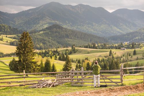 Romania Landscape Photography Photographer taking a photo of a rural Transylvania landscape at sunset Piatra Fantanele Transylvania Romania