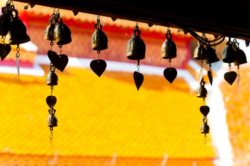Thailand Travel Photography Close up of prayer bells silhouetted against the colourful roof at Wat Doi Suthep Chiang Mai Thailand Southeast Asia
