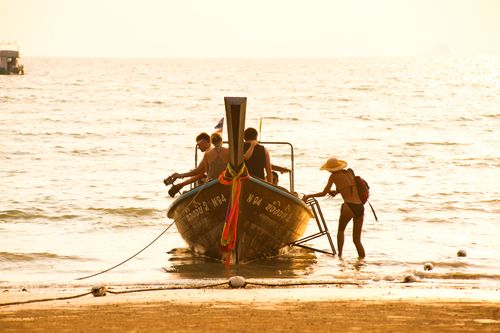 Thailand Travel Photography Tourists in a Traditional Thai Boat at Sunrise on East Railay Beach Rai Leh South Thailand Southeast Asia