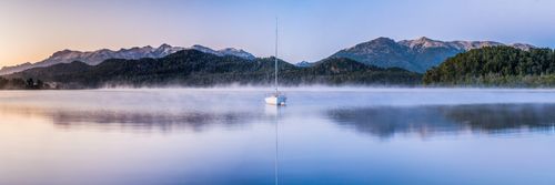 Landscape Photography by Professional Freelance UK Landscape Photographer Sailing boat on a misty sunrise at Nahuel Huapi Lake Villa la Angostura Neuquen Patagonia Argentina South America background with copy space